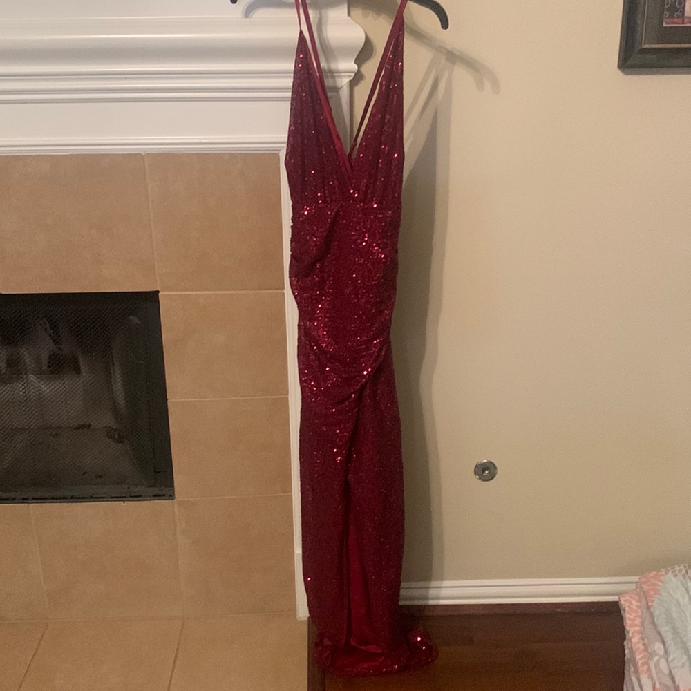 BURGUNDY SEQUIN DRESS WITH SLIT ON LEG. BACKLESS AND STRAPS CROSS IN THE BACK.